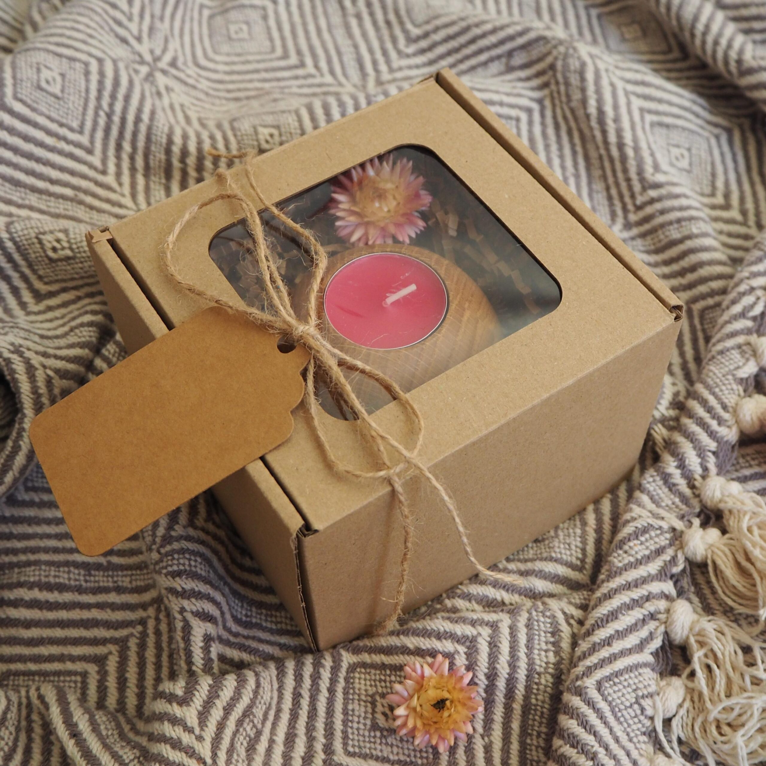 Zestaw prezentowy w eko pudełku z drewnianym świecznikiem na tealighty o kształcie kuli z różową świecą tealight i suszonym kwiatem. Opleciony sznurkiem jutowym.